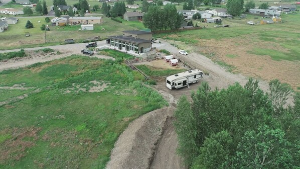 Vista aérea de una zona residencial con una casa de un piso, un camino de entrada y una caravana estacionada.