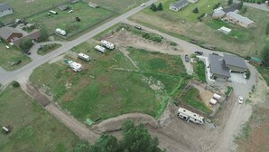 An aerial view of a residential area with multiple RVs parked in a spacious lot, surrounded by houses and a fenced playground.