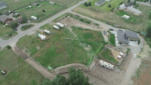 Vista aérea de una zona residencial con varias casas rodantes estacionadas en un amplio terreno, rodeado de viviendas y un parque infantil vallado.