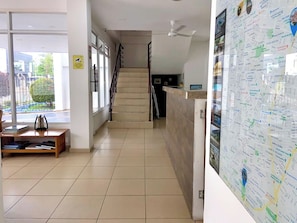 A hotel lobby with a staircase, a reception desk, and a wall with a map. - Hotel Sofichic by Caribecheap (Barranquilla)