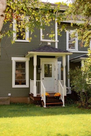 A two-story house with a porch, a front door, and a small front yard. - Quartier Layk : Suite 1186 - Ayers Cliff (Ayer's Cliff)