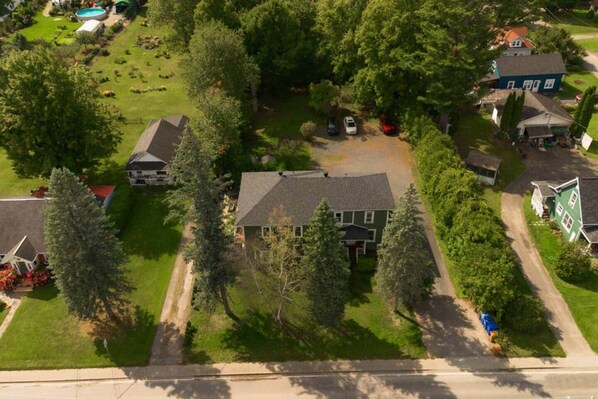 Vista aérea de un área residencial con casas, árboles y una piscina.