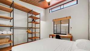 Une chambre à coucher avec un lit, un bureau et des étagères.