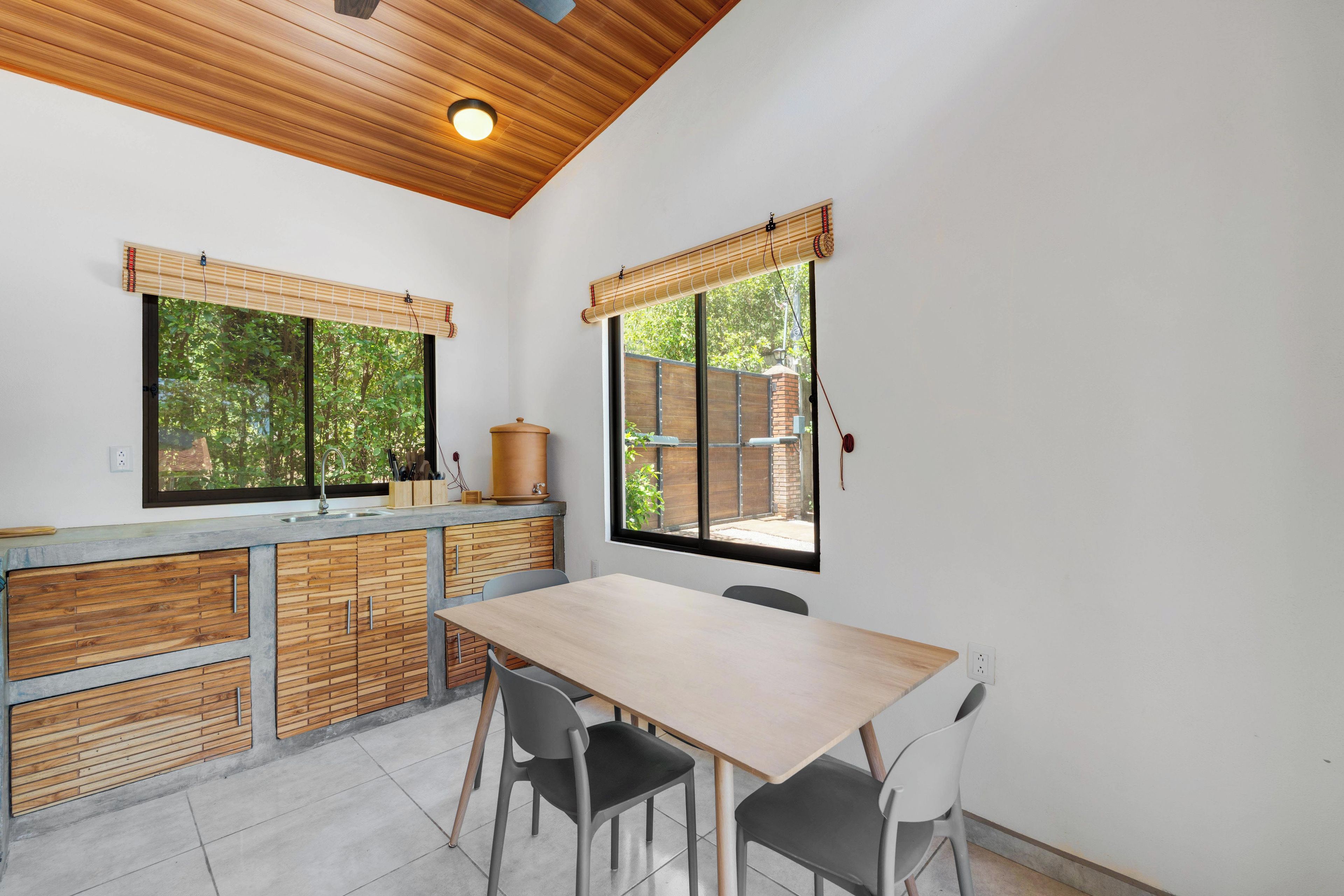 Une cuisine dotée d’un plan de travail en bois, d’un évier et d’un coin repas avec des chaises.