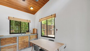 Une cuisine dotée d’un plan de travail en bois, d’un évier et d’un coin repas avec des chaises.