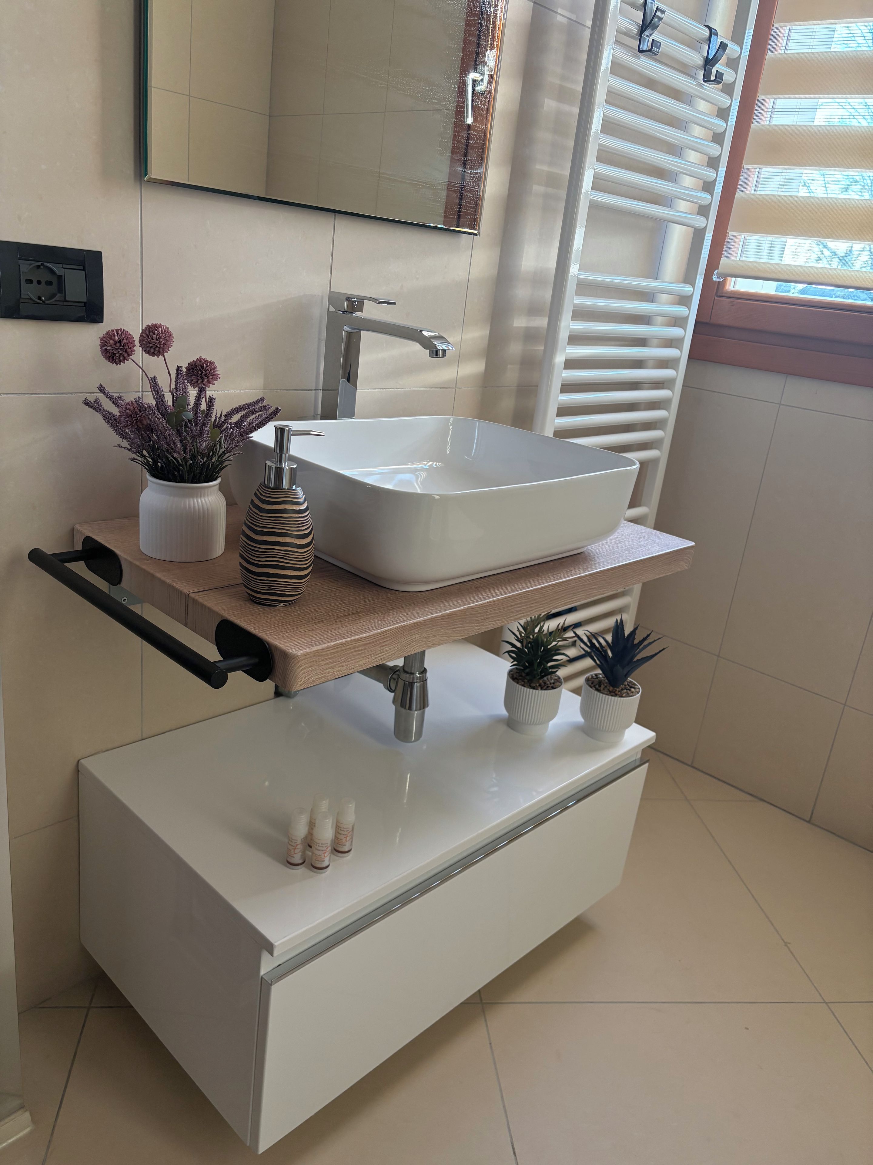A modern bathroom with a large rectangular sink, a mirror, and a towel rack.