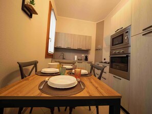 A compact kitchen with wooden cabinets, a built-in microwave, and a stove.