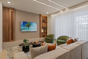 Ein modernes Wohnzimmer mit einer Eckcouch, einem Couchtisch, einem Strandbild und einer Wand mit Holzakzenten.