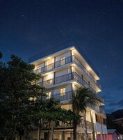 A multi-story hotel with balconies, under a starry night sky.
