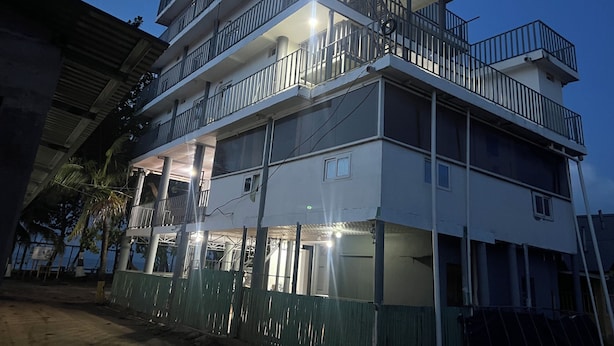 A multi-story building with balconies and a covered entrance area.