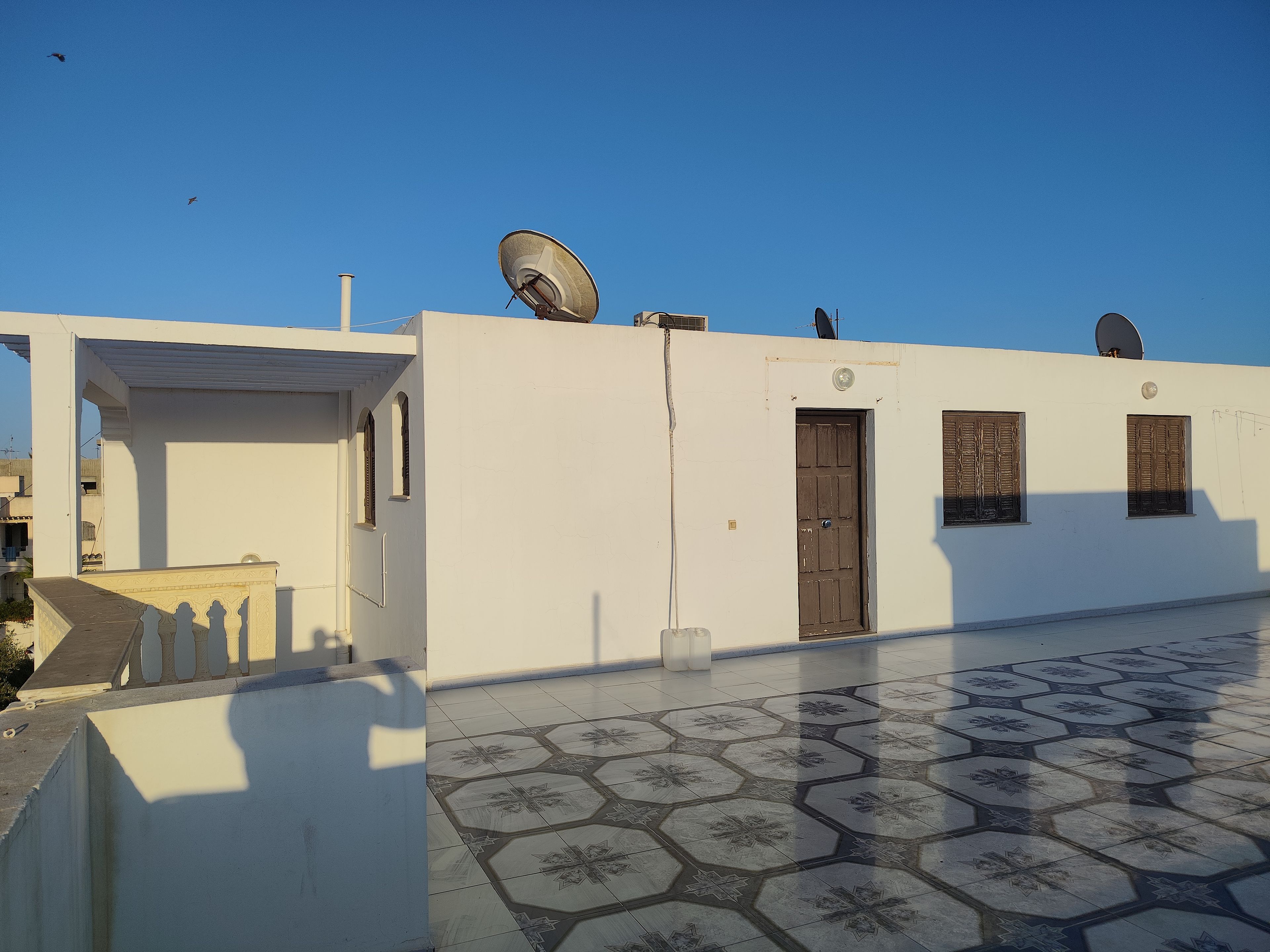 A building with satellite dishes, a tiled floor, and a door.