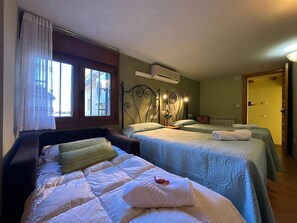 A hotel room with two beds, a window with curtains, an air conditioning unit, and a door.