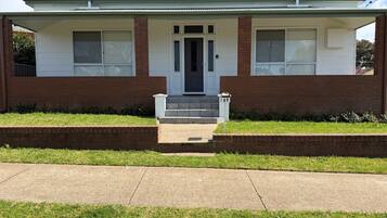 A single-story house with a front porch, a mailbox, and a number 69 sign.
