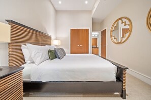 A modern hotel room with a bed, bedside table, lamp, and a wooden headboard. - Singing Pass at Fitzsimmons Walk (Whistler)