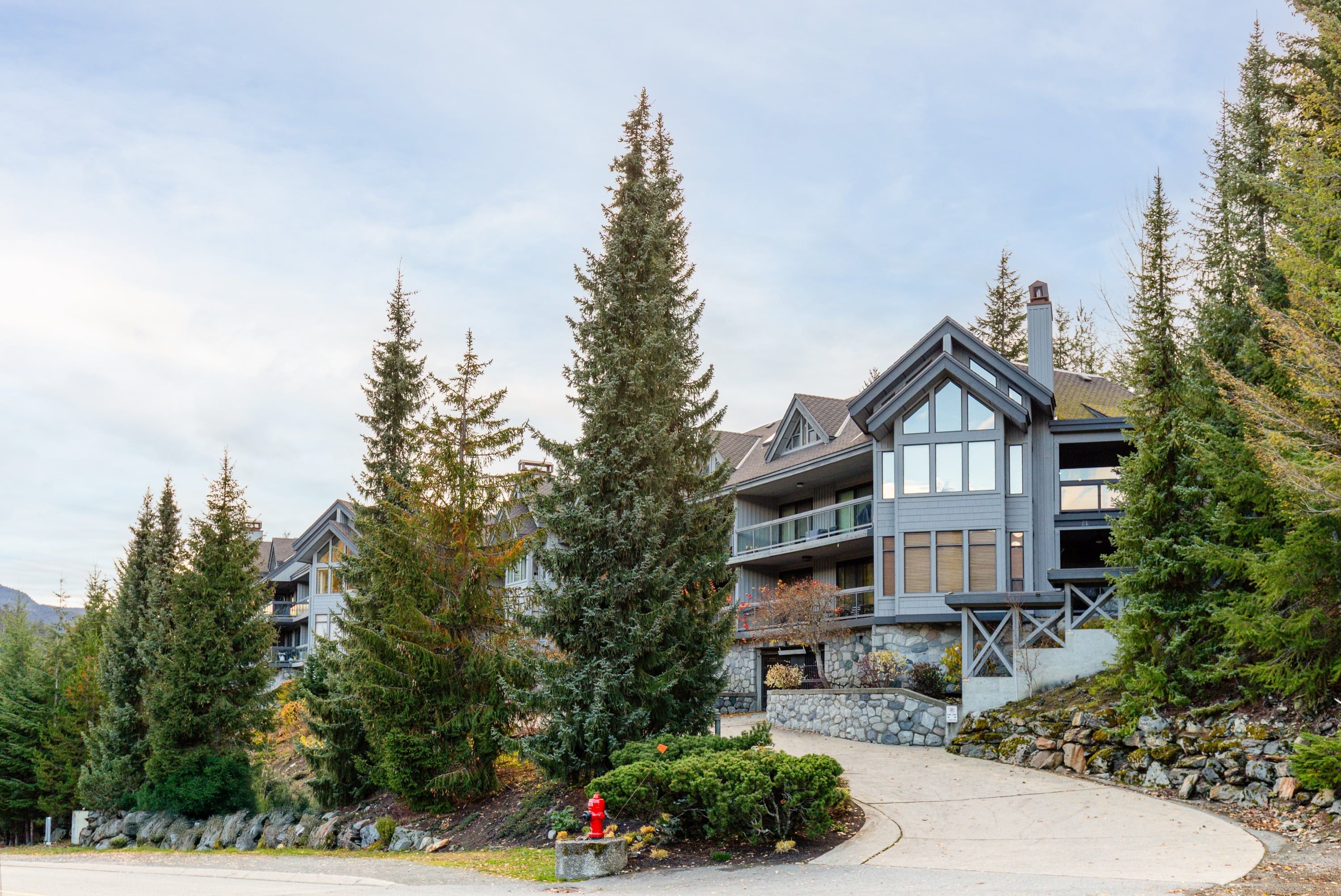 A multi-story building with a stone facade, large windows, and a prominent balcony area.