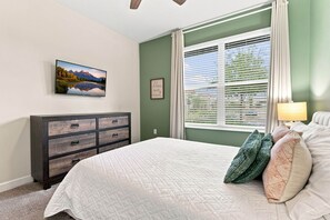 A bedroom with a bed, dresser, window with blinds, and a picture on the wall. - Perfect Family Escape Pool Themed Rooms (Kissimmee)