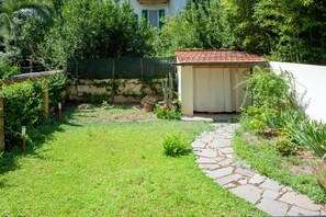 Ein Garten mit einem Kiesweg, der zu einem kleinen Schuppen führt.