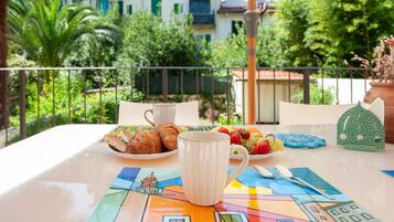 Ein Tisch mit Frühstücksgebäck, einer Tasse und einer bunten Tischdecke.