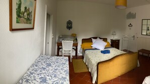 Een slaapkamer met een bed, een bureau, een stoel, een kledingkast en een spiegel.