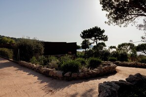 A coastal property with a stone wall, a wooden pergola, and a view of the sea. - Luxury boutique hotel with ocean views and a beach within walking distance (Pietrosella)