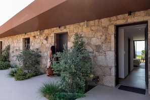 Fachada de piedra con un acceso a un interior moderno.