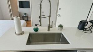 Uma casa de banho moderna com lavatório, sanita, espelho e zona de duche.