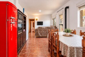 A compact living space with a dining area, a red appliance, and a television. - Villa Los Castros | Authentic Andalusian Villa in Bédar (Bédar)