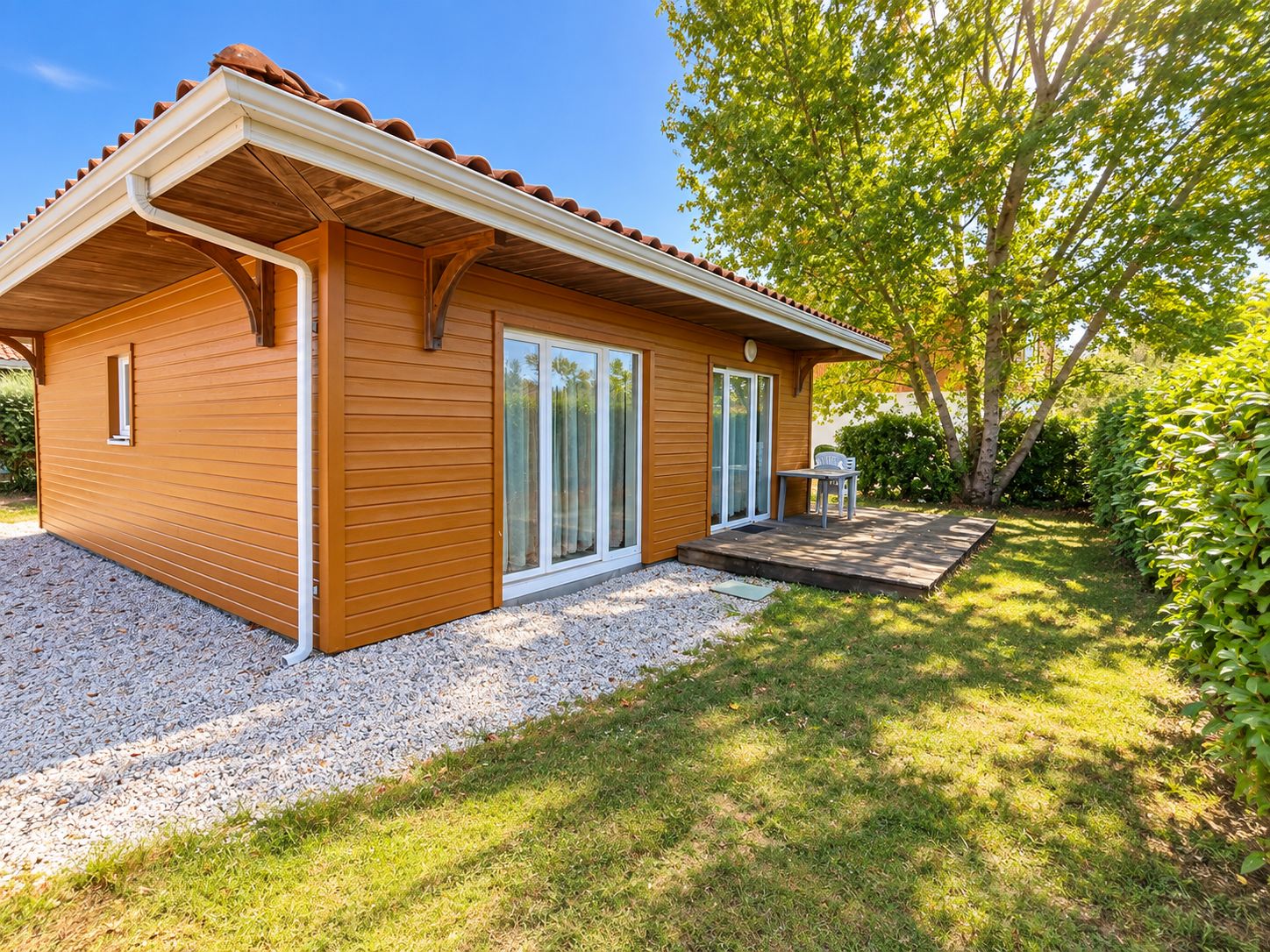 A single-story house with a covered porch, a sliding glass door, and a gravel driveway.