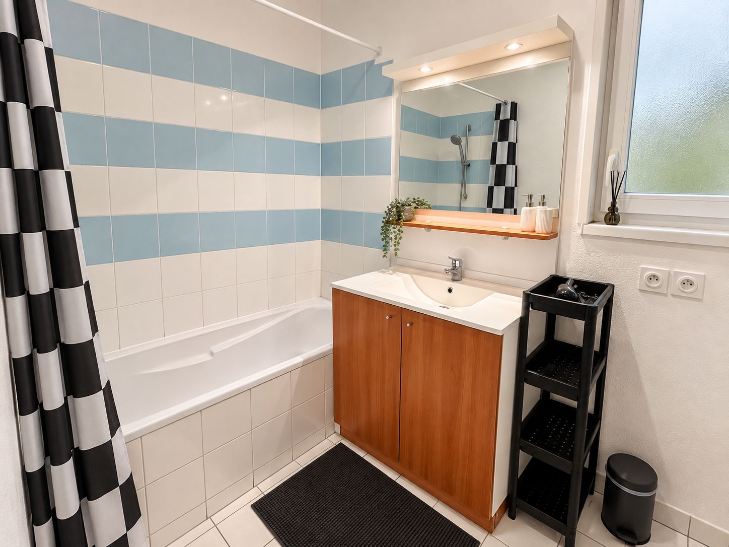 A bathroom with a bathtub, a sink, a mirror, and a shower area.