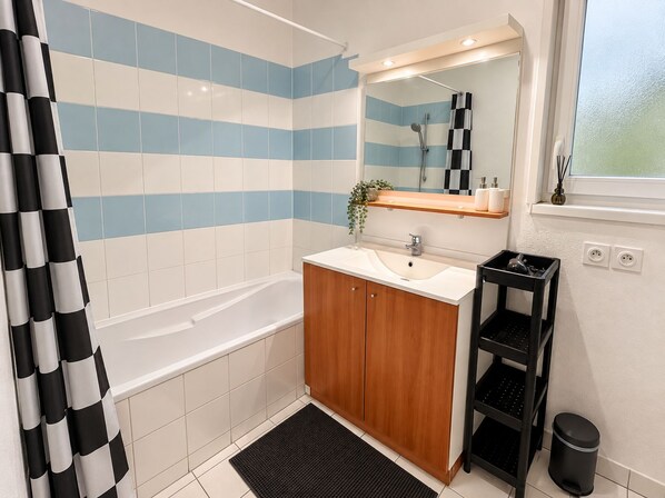 A bathroom with a bathtub, a sink, a mirror, and a shower area. - Villa for 6 people at Domaine des Grands Lacs – Pools & Lake (Parentis-en-Born)