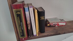 Une étagère en bois avec des livres et un jeu de dés.