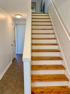 A staircase with wooden steps and white walls. - Reel Retreat near MSU 2 BED (Starkville)