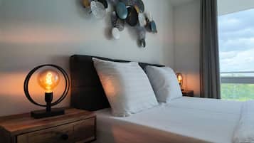 Una camera da letto con un letto, due lampade da comodino, un comodino in legno e un elemento decorativo a parete.