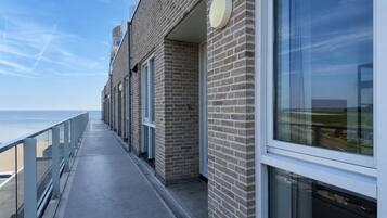 Un bâtiment doté d’un long couloir menant à un balcon qui donne sur une étendue d’eau.