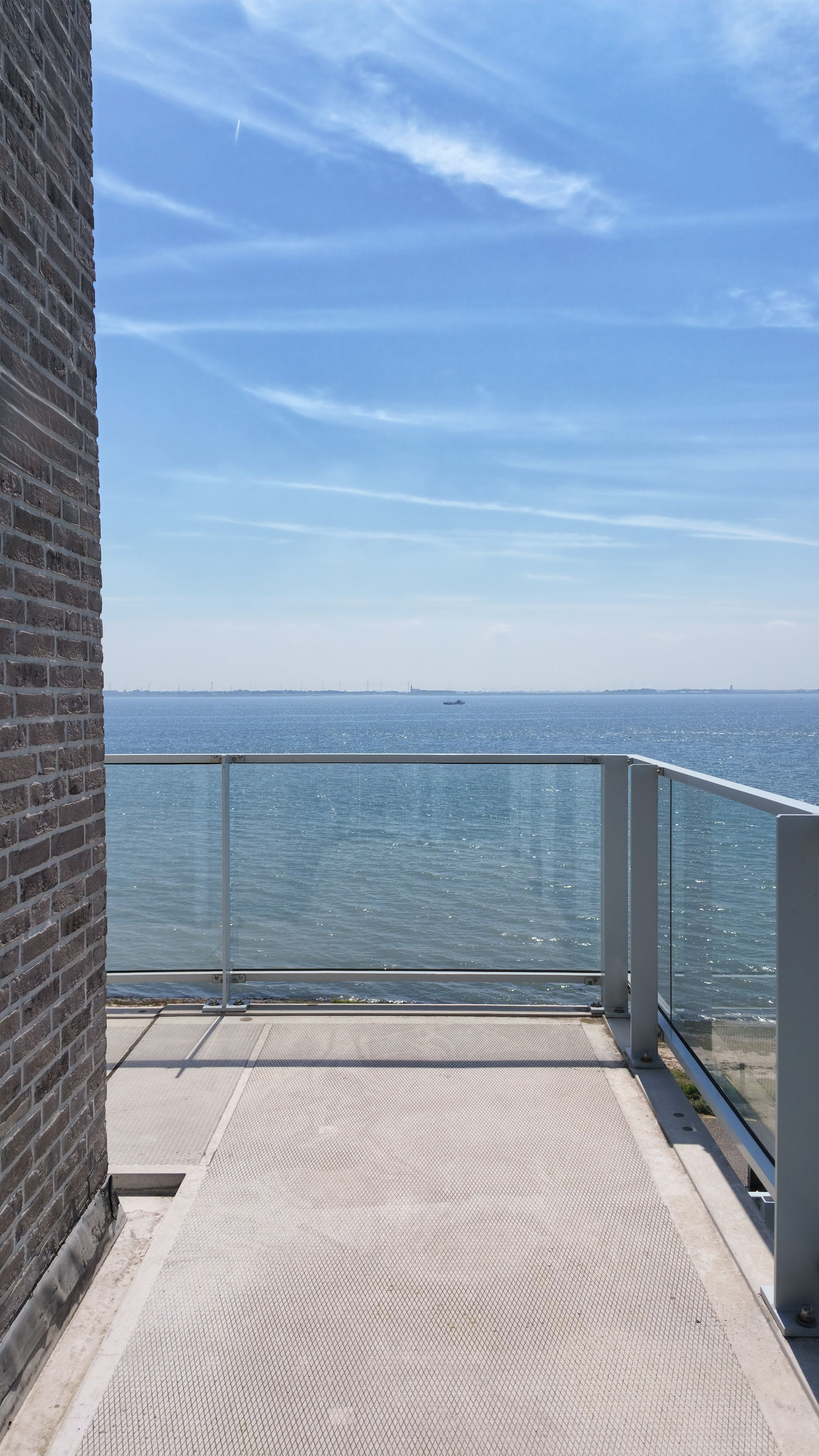 Un balcón con vista despejada al mar y al horizonte de la ciudad.