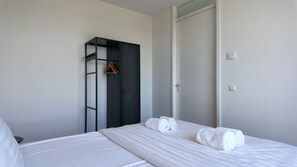 Una habitación de hotel con una cama, un armario y una puerta.