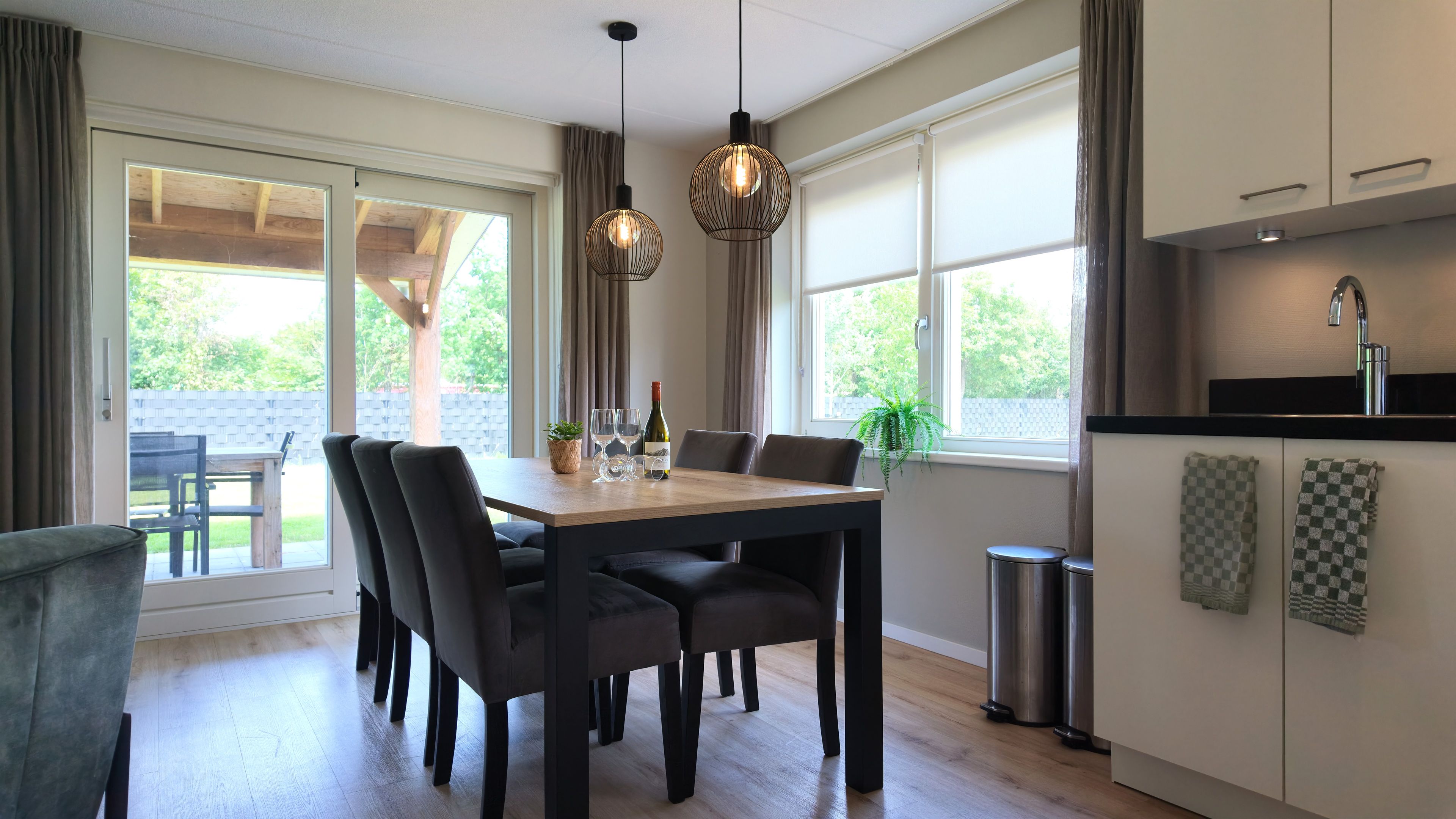 Una cucina moderna con zona pranzo, ampie finestre e vista sull'esterno.