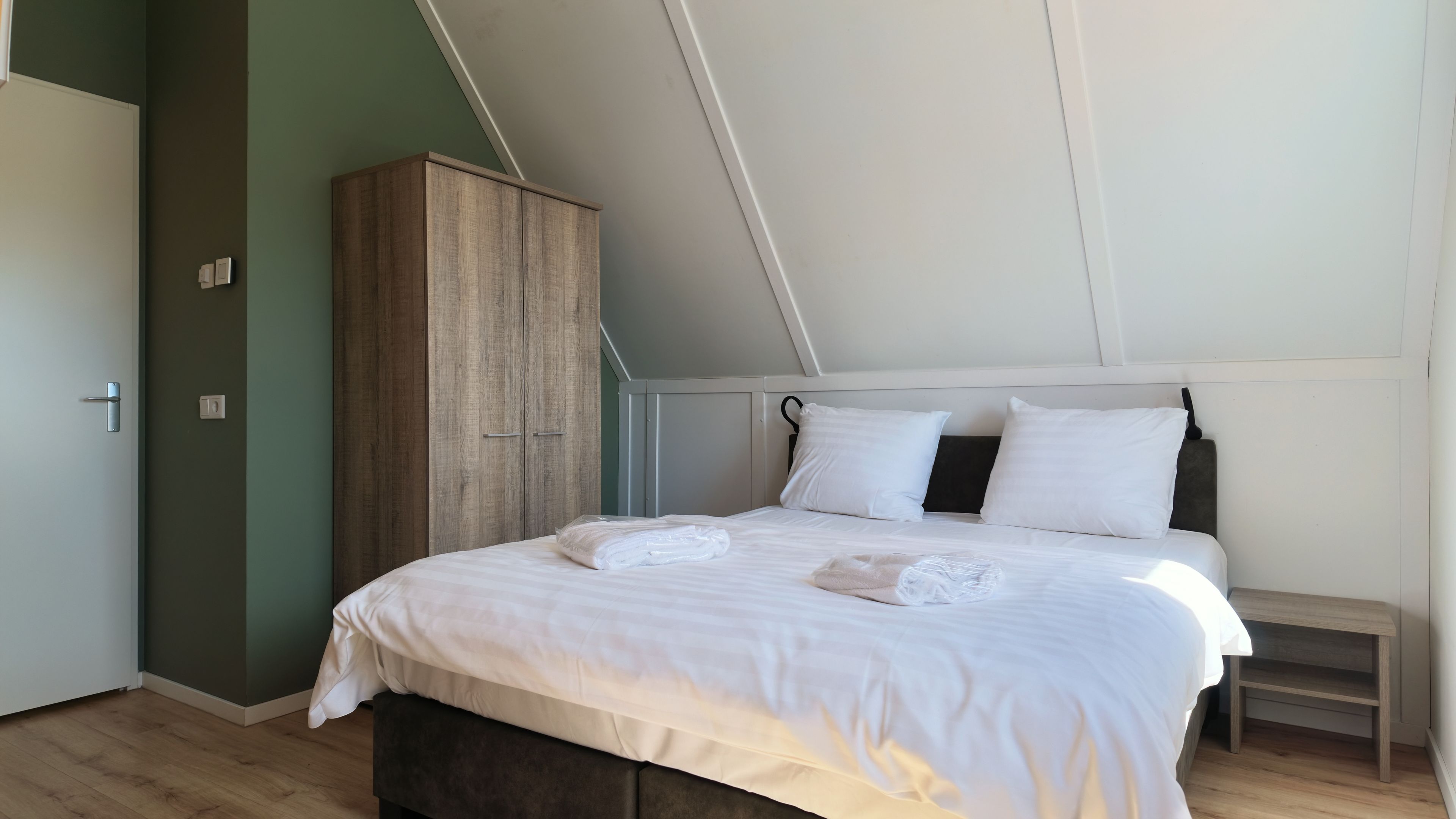 Une chambre à coucher avec un lit, une armoire et une table de chevet.