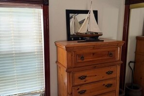 A wooden dresser with drawers and a mirror with a sailboat reflection. - Cozy 2-bedroom cabin on the Amite River that sleeps 8 adults (Saint Amant)