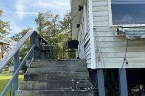 Una escalera conduce a una casa con un ventanal que muestra el logotipo de Bud Light.