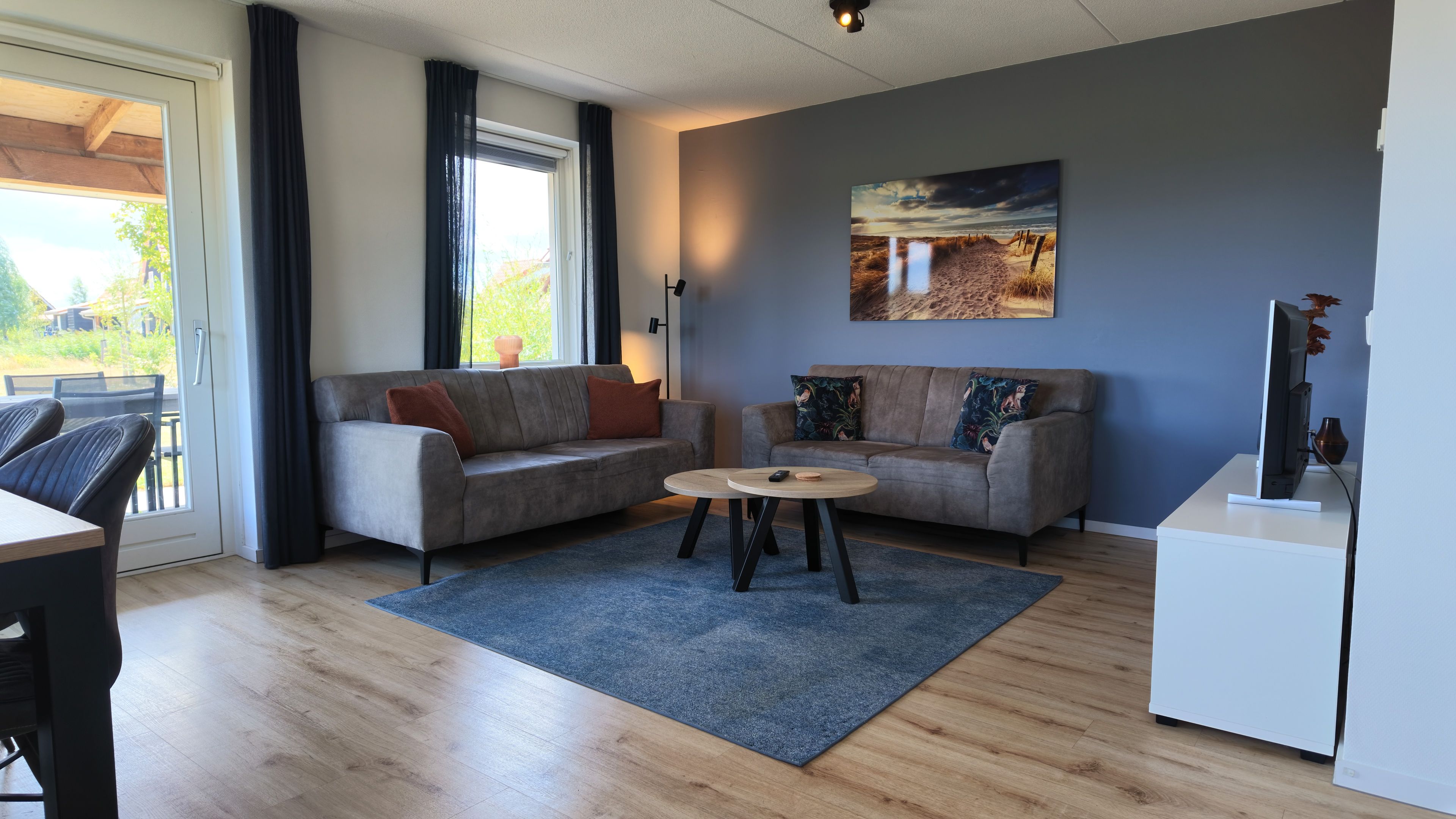 Un salon moderne avec deux canapés, une table basse et un téléviseur à écran plat.
