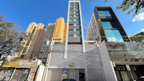 Un immeuble à plusieurs étages qui présente un mélange de styles architecturaux, notamment des éléments modernes et traditionnels.