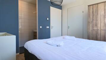 Een hotelkamer met een bed, een kledingkast en een badkamer.