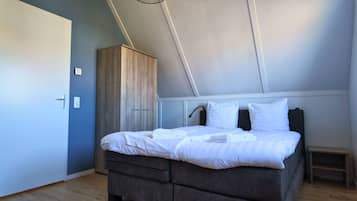 Una camera da letto con un letto, un armadio e un comodino.