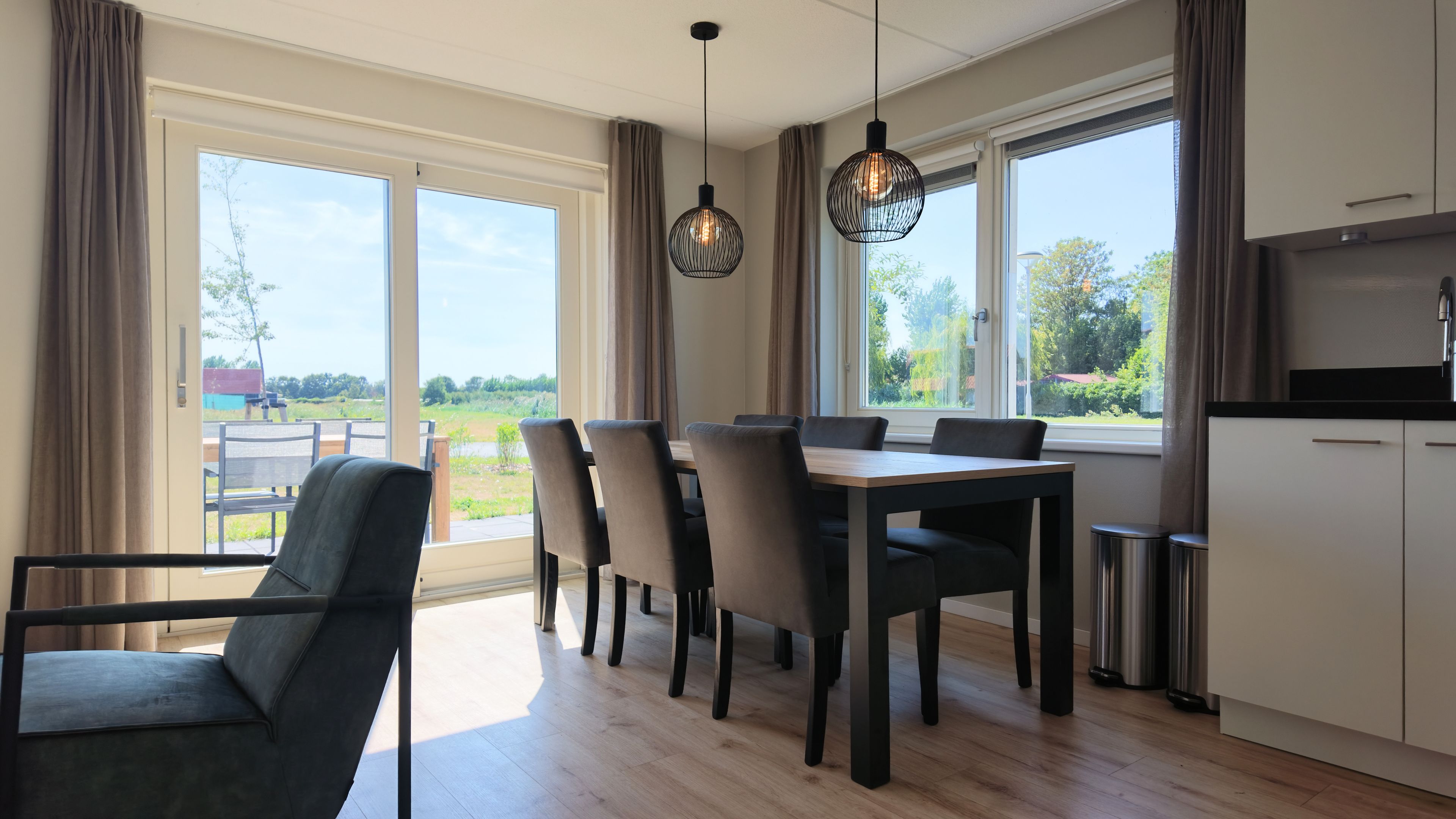 Una cocina moderna con comedor, ventanas amplias y vistas al exterior.