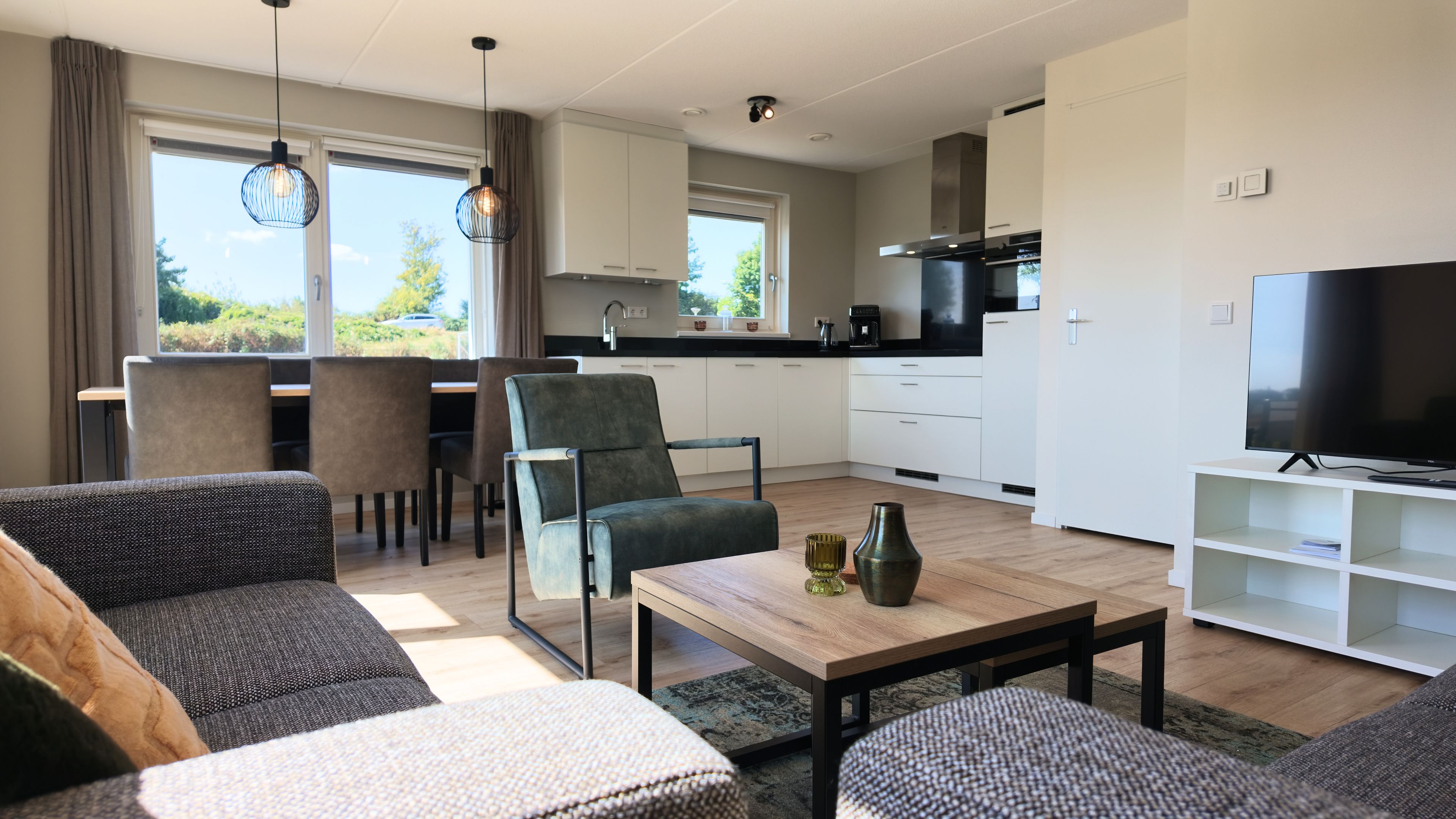 Een moderne woonkamer met een bank, salontafel en televisie.
