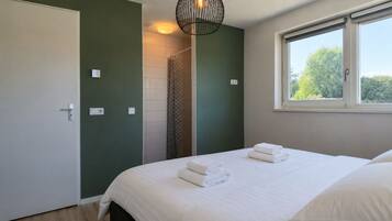 Une chambre à coucher avec un lit, une fenêtre et un espace douche.
