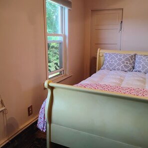 Un dormitorio con una cama, una ventana y una puerta.