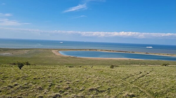 A coastal landscape with a curved bay, grassy terrain, and a clear sky. - Studio Ô de Mer - 20 meters from the beach in Sangatte (Sangatte)