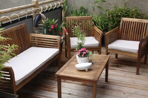 A wooden deck with a sofa, two chairs, and a table with a potted plant. - Studio Ô de Mer - 20 meters from the beach in Sangatte (Sangatte)